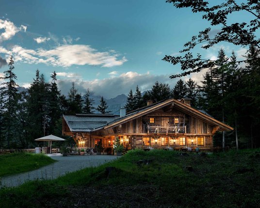 Aufnahme der beleuchteten Interalpen-Alm des MICE Hotels bei Nacht