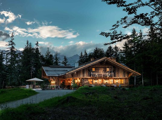 Aufnahme der beleuchteten Interalpen-Alm des MICE Hotels bei Nacht
