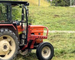 A tractor is mowing the meadow in the Interalpen A tractor is mowing the meadow in the Interalpen