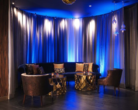 Events im Interalpen Einblick in die Lounge einer Eventlocation in Österreich, beleuchtet mit blauem Licht