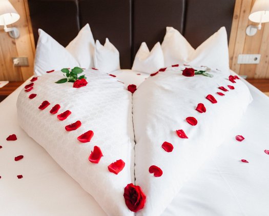 Room decorations Frontal shot of large double bed decorated with red roses for a wedding