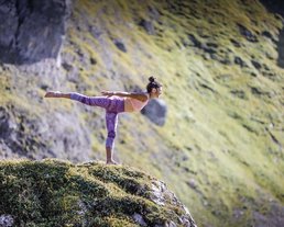 ©Carry Yoga Aufnahme einer Frau in einer Yogaposition auf einem Berg in ihrem Yoga-Urlaub in Österreich
