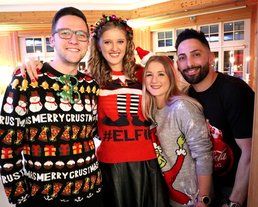 Mitarbeiter:innen auf der Weihnachtsfeier mit Weihnachtspullovern in einem 5-Sterne Hotel