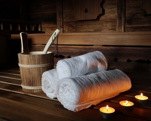 Sauna Aufguss in einer Sauna mit gemütlichem Licht und frischen Handtüchern