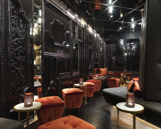Lounge Einblick in das Hofburg Restaurant mit schwarzem Gang und orangenen Sitzen