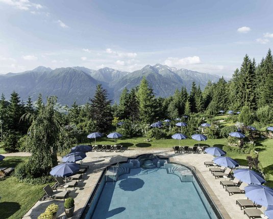 Blick auf den großen Außenpool im Garten des 5 Sterne Superior Interalpen-Hotel Tyrols