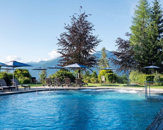 Panorama-Pool mit Bergblick Aufnahme des Outdoor Pools im Garten des Hotels mit bequemen Liegemöglichkeiten