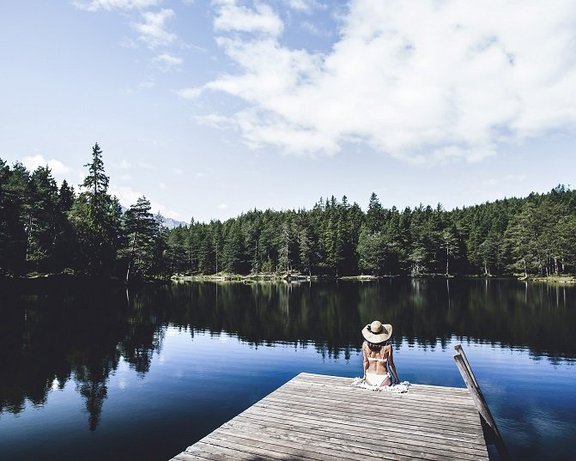 © Region Seefeld, Stephan Elsler_Möserer_See Frau sitzt am Steg des Möserer Sees im Sommer