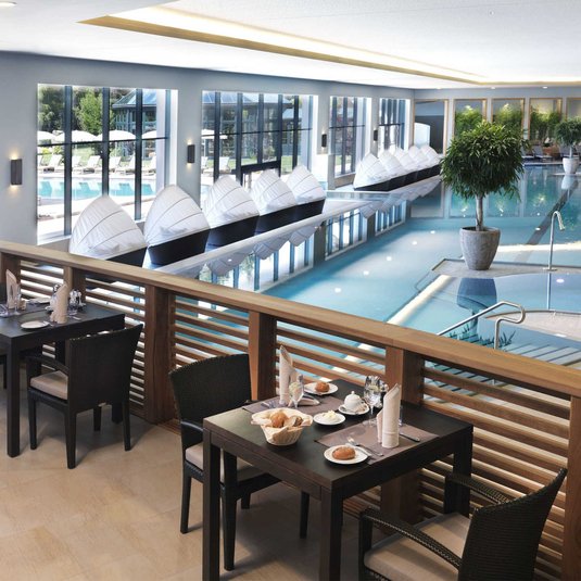 Spa-Restaurant Aufnahme gedeckter Tische für das Frühstück im Spa-Restaurant mit Blick auf den Poolbereich