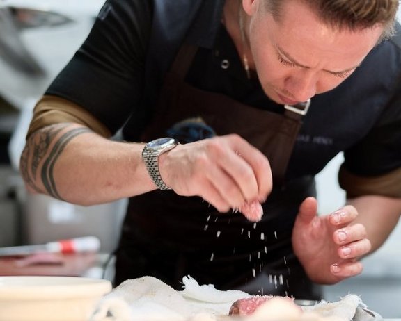 Mathias’ feines Gespür für die Kunst der Kulinarik Mathias beim Würzen und Vorbereiten von Fisch für das Interalpen-Culinarium 2026