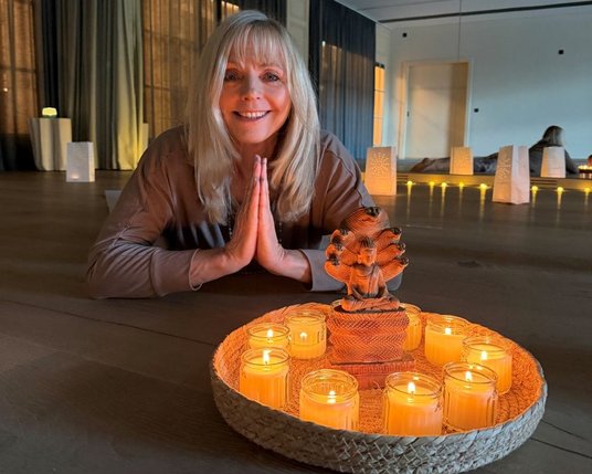 Experience the tranquility of the Advent season with yoga led by Christianne Hosemann Yoga instructor Christiane Hosemann next to beautifully lit candles in our yoga studio