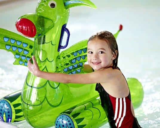 Kind im Schwimmbecken eines Kinderhotels