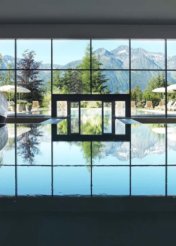 Aufnahme des Panorama Pools im lichtdurchfluteten Spa-Bereich des Wellnesshotels Tirol