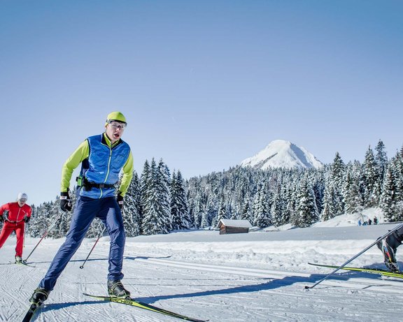 Mehrere Personen beim Langlaufen in einer schneebedeckten Landschaft in Seefeld 