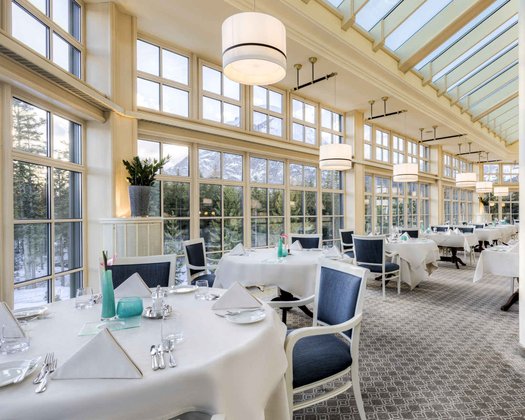Outlets im Interalpen-Hotel Tyrol Einblick in den großzügigen und schön dekorierten Innenbereich mit großen Glasfronten im Wintergarten in einem Restaurant bei Seefeld