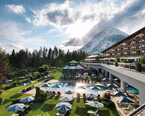 Locations Außenansicht des Interalpen-Hotels Tyrol an einem schönen Sommertag