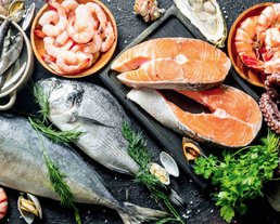 Frischer Fisch und Meeresfrüchte Eine Nahaufnahme von frischem Fisch und verschiedenen Meeresfrüchten mit Kräutern