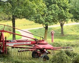 A tractor is mowing the meadow in the Interalpen A tractor is mowing the meadow in the Interalpen